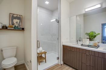 Large bathrooms with quartz vanities and large showers with full ceramic-tile surrounds